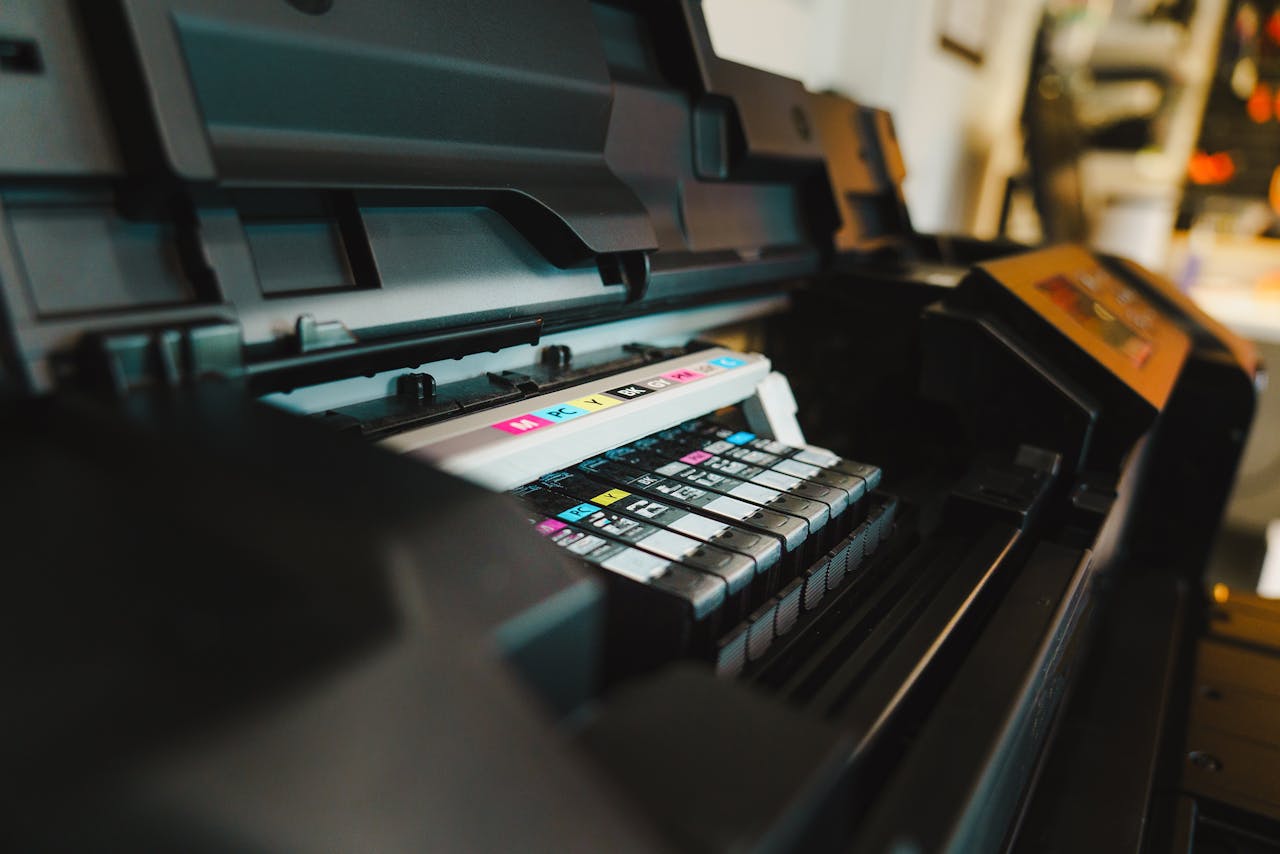 why-choose-us Detailed view of ink cartridges inside a digital inkjet printer in an office setting.