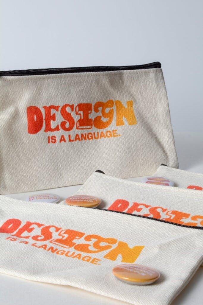 Stylish canvas pouches featuring design quotes and colorful buttons against a minimalist backdrop.