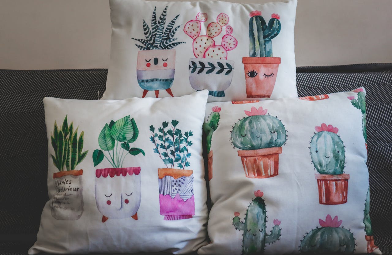 about-02 A collection of artistic plant-themed throw pillows on a sofa.